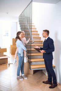 handsome broker talking with woman holding in arms cute daughter